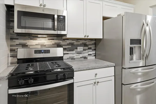 a kitchen with stainless steel appliances granite countertop a stove microwave and refrigerator