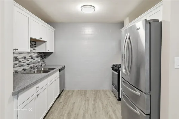 a kitchen with stainless steel appliances a refrigerator sink and stove