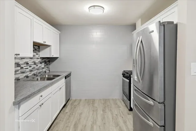 a kitchen with stainless steel appliances a refrigerator sink and stove