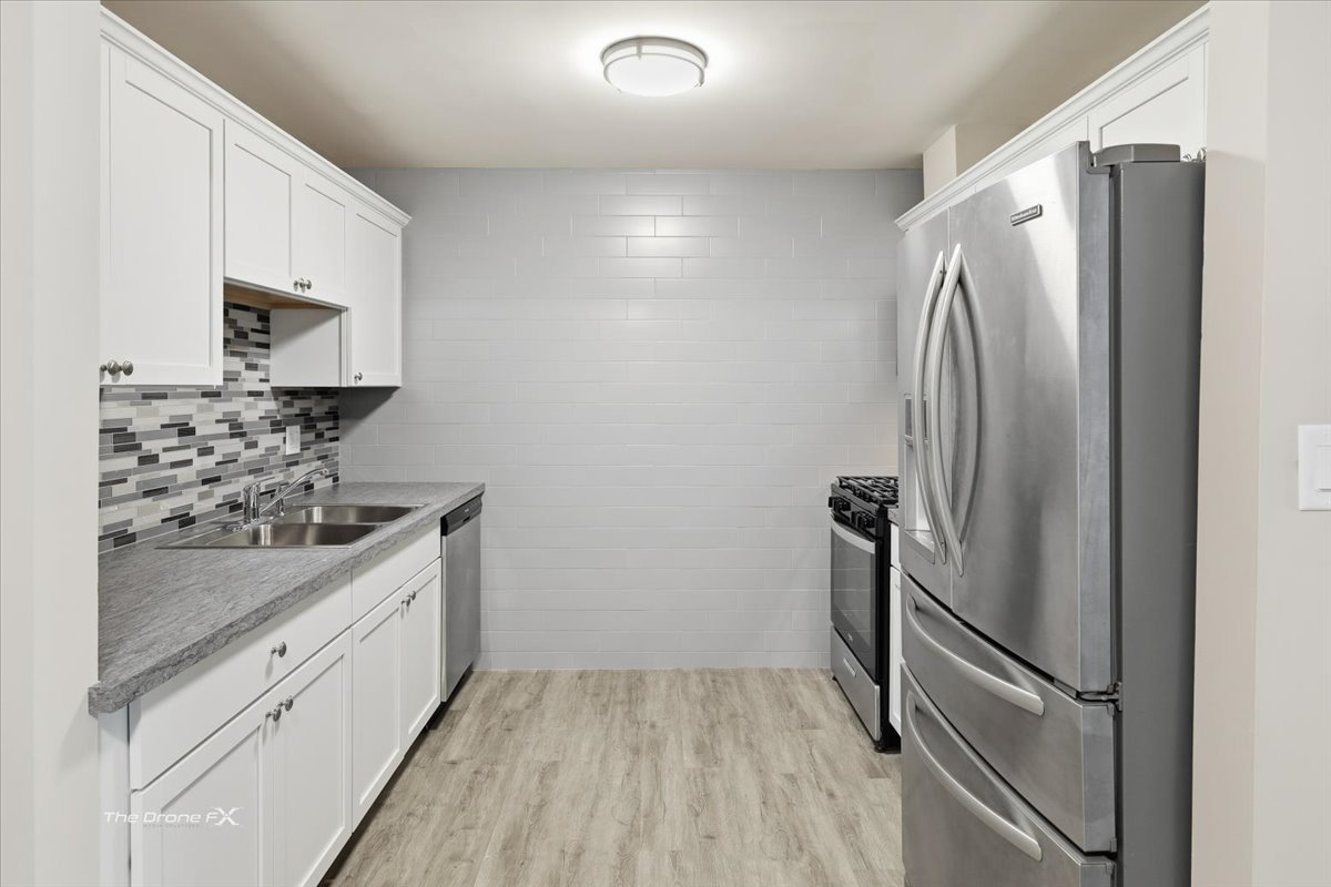 144 East Bailey Road, Unit L Naperville, IL 60565 - Photo 7 of 12 a kitchen with stainless steel appliances a refrigerator sink and stove