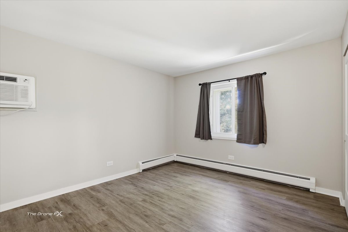 144 East Bailey Road, Unit L Naperville, IL 60565 - Photo 9 of 12 an empty room with wooden floor and windows