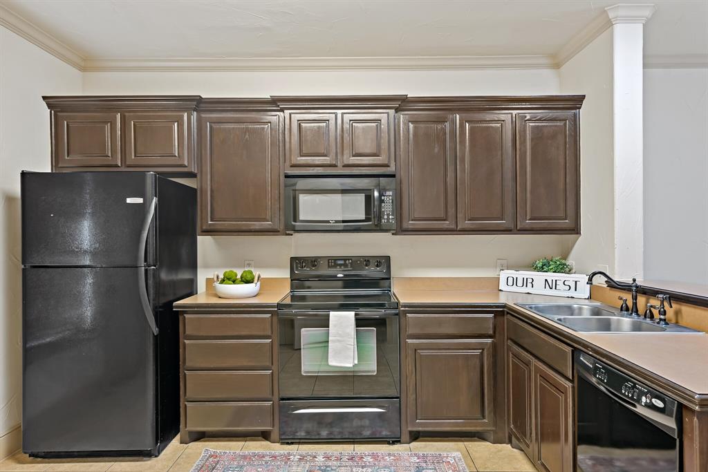 11118 Marion Road, Unit 105 Sanger, TX 76266 - Photo 11 of 29 Kitchen featuring wood-finish cabinetry with crown molding, a black electric range, and a black microwave