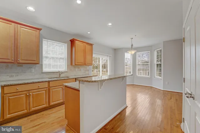 a kitchen with granite countertop wooden floors and white cabinets