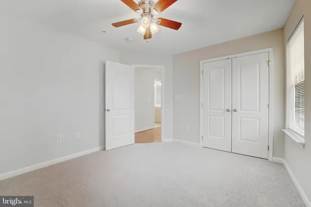 an empty room with closet and windows