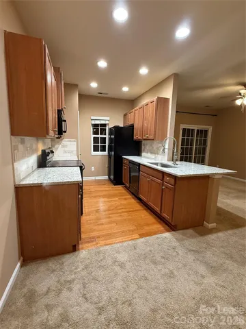 a large kitchen with kitchen island a sink appliances and cabinets