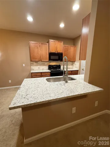 a kitchen with kitchen island a sink stainless steel appliances and cabinets