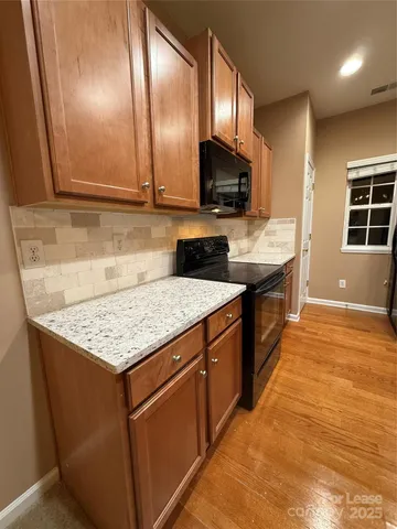 a kitchen with stainless steel appliances granite countertop a stove a sink and a microwave