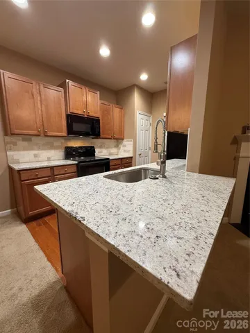 a kitchen with stainless steel appliances granite countertop a sink stove and microwave