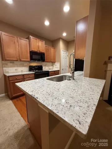 a kitchen with stainless steel appliances granite countertop a sink stove and microwave