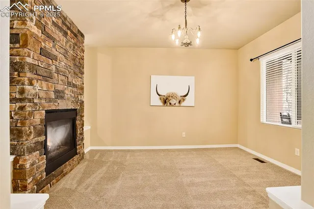 a view of an empty room with a fireplace and a window