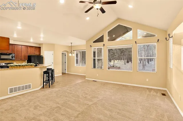 a view of a kitchen with kitchen island stainless steel appliances windows