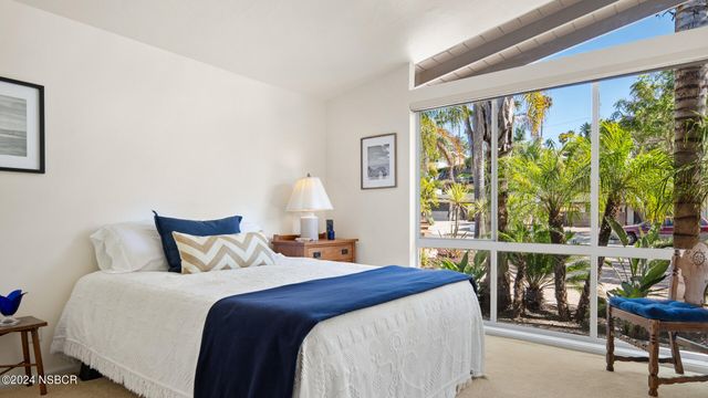 a bedroom with a bed a table and a large window