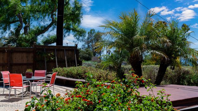 a view of backyard with seating space and green space