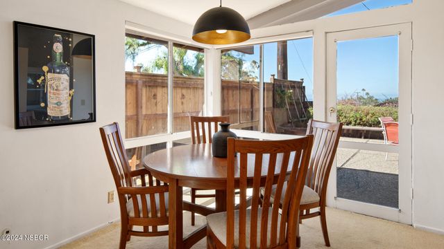 a dining room with furniture wooden floor a potted plant and a chandelier