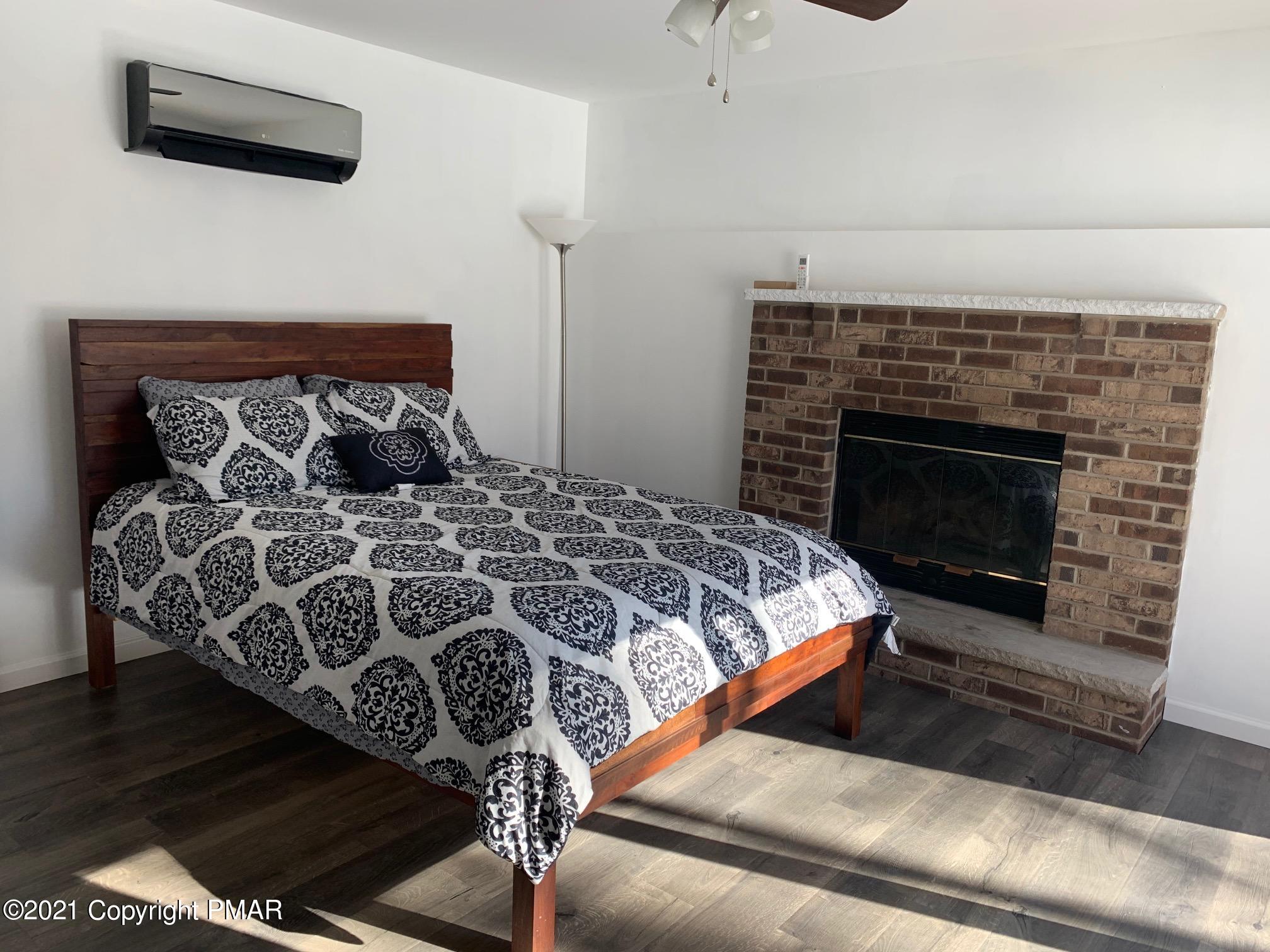 303 Otter Court Bushkill, PA 18324 - Photo 18 of 23 a bedroom with a bed and a fireplace