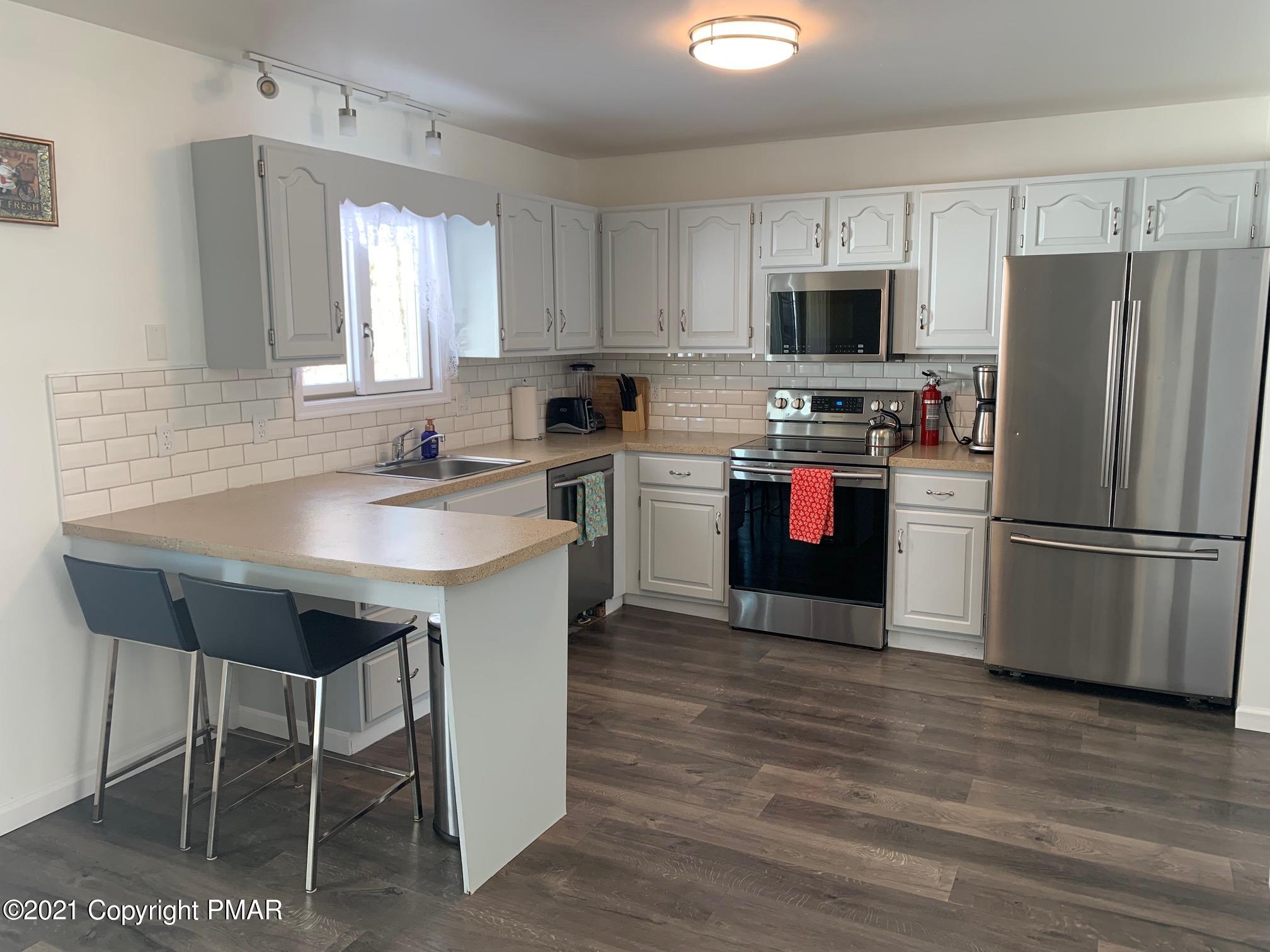 303 Otter Court Bushkill, PA 18324 - Photo 3 of 23 a kitchen with stainless steel appliances a stove a sink refrigerator and a microwave