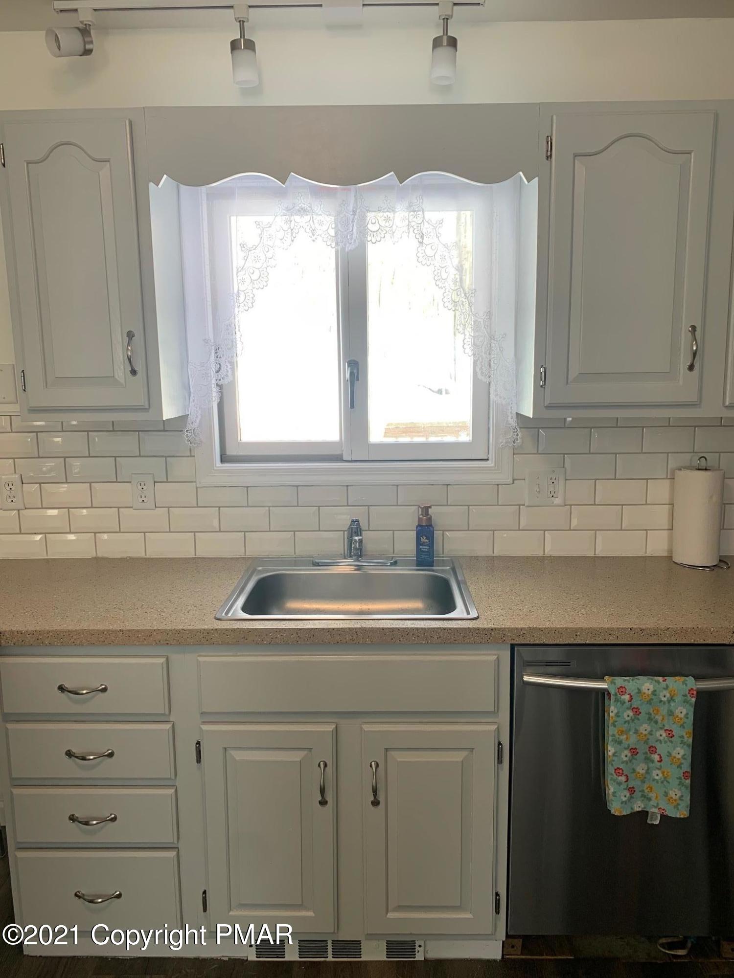 303 Otter Court Bushkill, PA 18324 - Photo 5 of 23 a kitchen with cabinets appliances a sink and a window