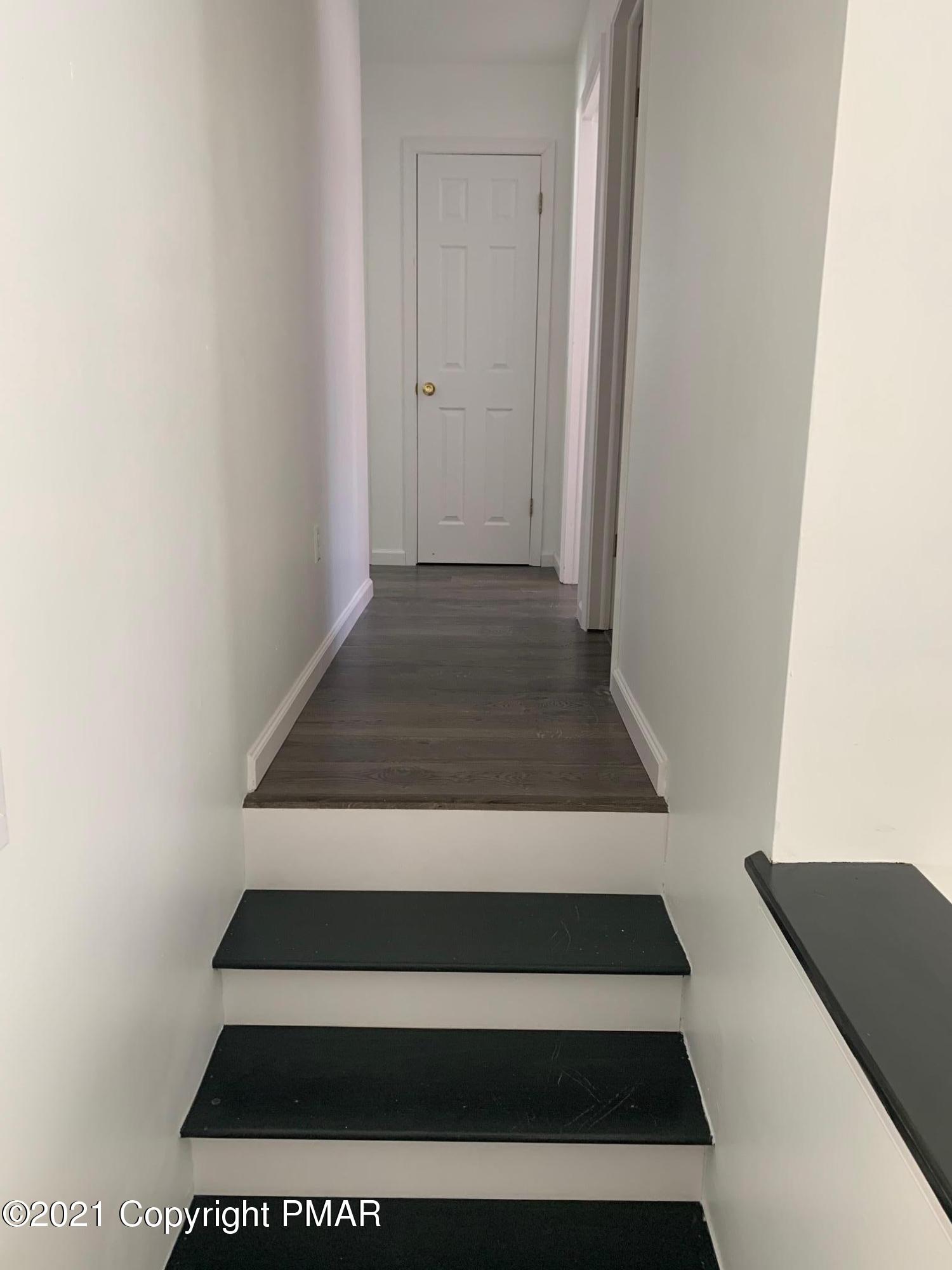 303 Otter Court Bushkill, PA 18324 - Photo 10 of 23 a view of a hallway with wooden cabinets and black white checkered floor