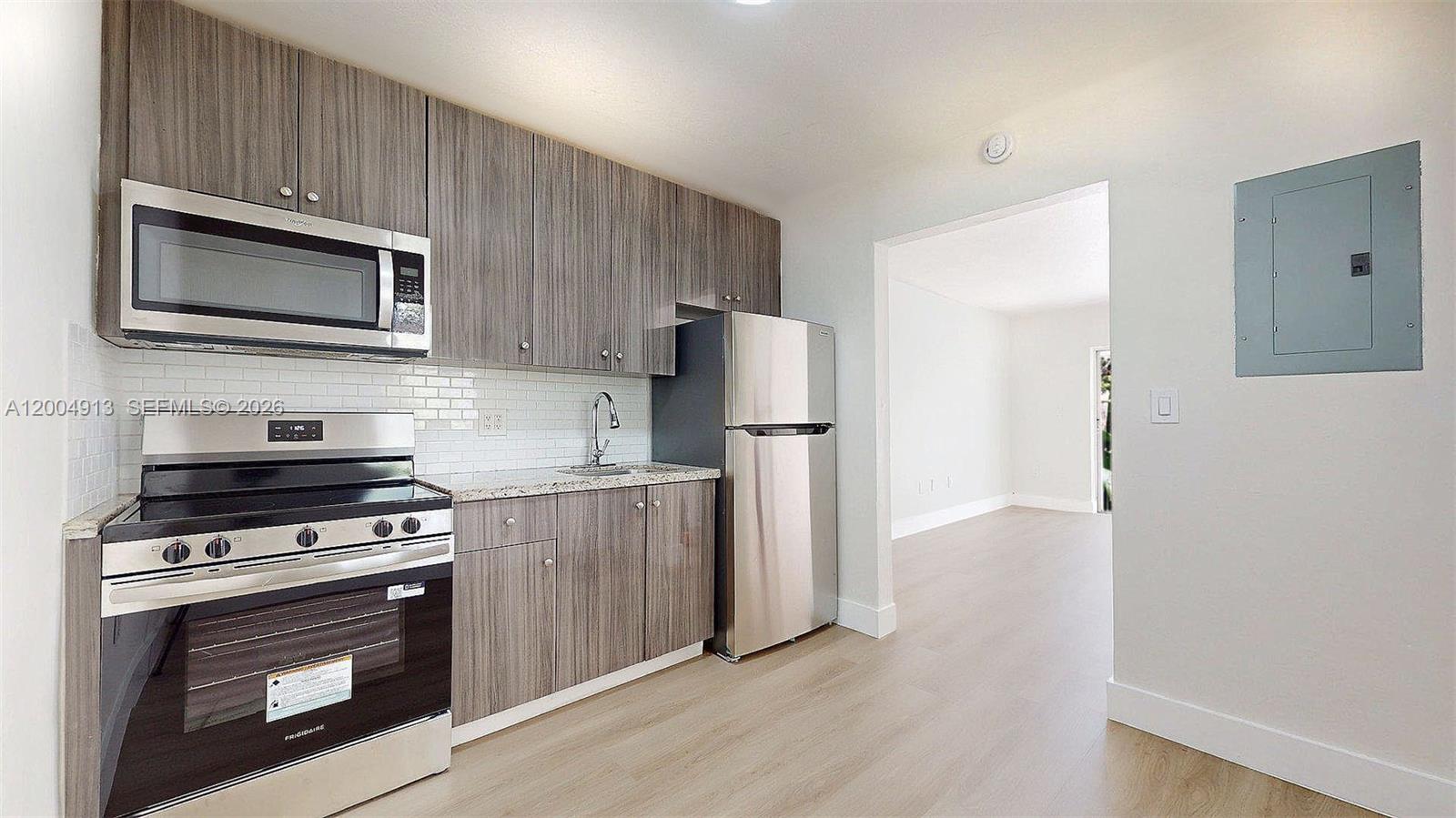 567 Southwest 3rd Street, Unit 2 Miami, FL 33130 - Photo 11 of 29 a kitchen with a stove microwave and refrigerator