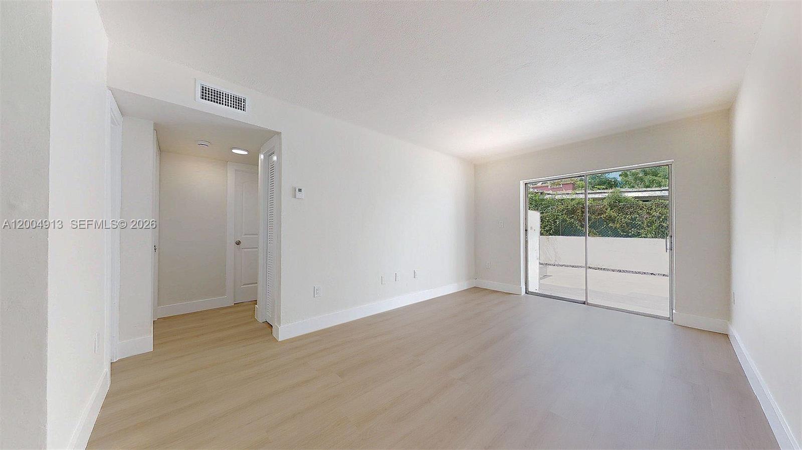 567 Southwest 3rd Street, Unit 2 Miami, FL 33130 - Photo 2 of 29 an empty room with wooden floor and windows