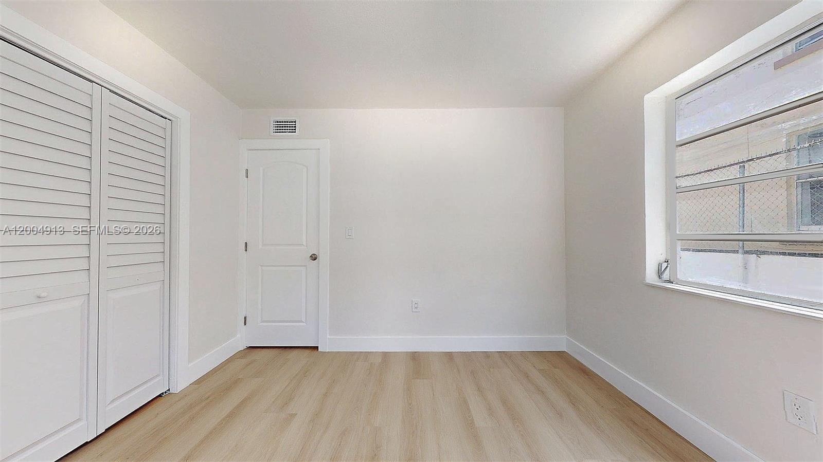 567 Southwest 3rd Street, Unit 2 Miami, FL 33130 - Photo 23 of 29 a view of an empty room with wooden floor and a window