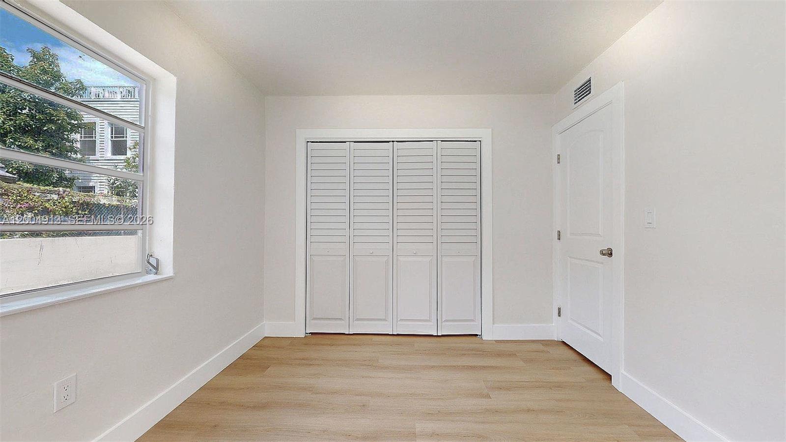 567 Southwest 3rd Street, Unit 2 Miami, FL 33130 - Photo 24 of 29 a view of an empty room with wooden floor and a window
