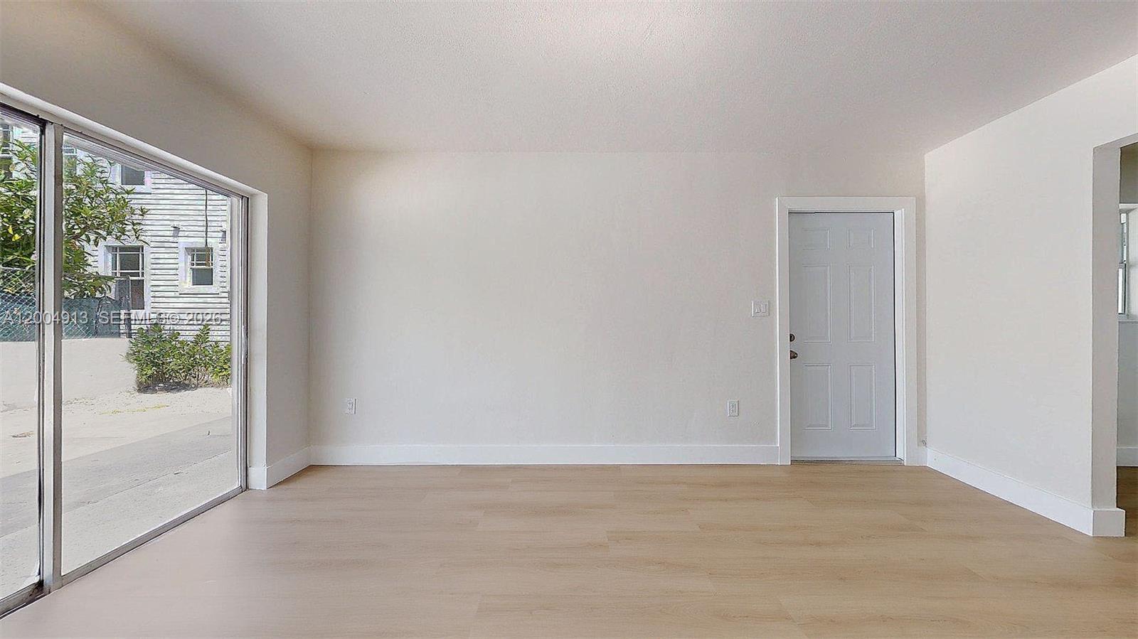 567 Southwest 3rd Street, Unit 2 Miami, FL 33130 - Photo 6 of 29 a view of an empty room with wooden floor and a window