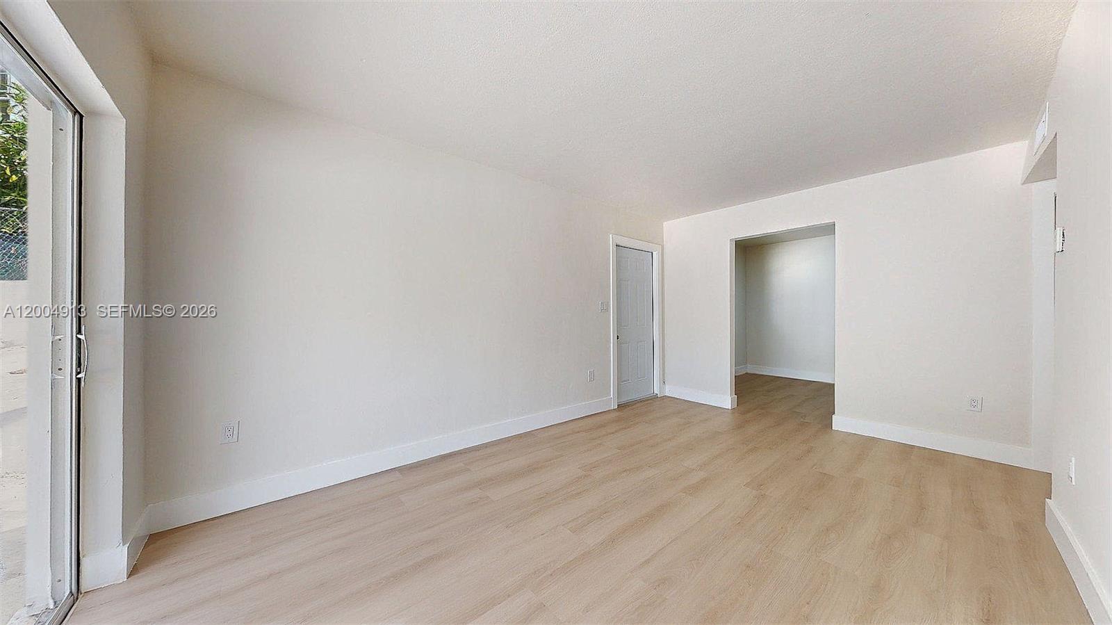 567 Southwest 3rd Street, Unit 2 Miami, FL 33130 - Photo 7 of 29 a view of an empty room with wooden floor and a window