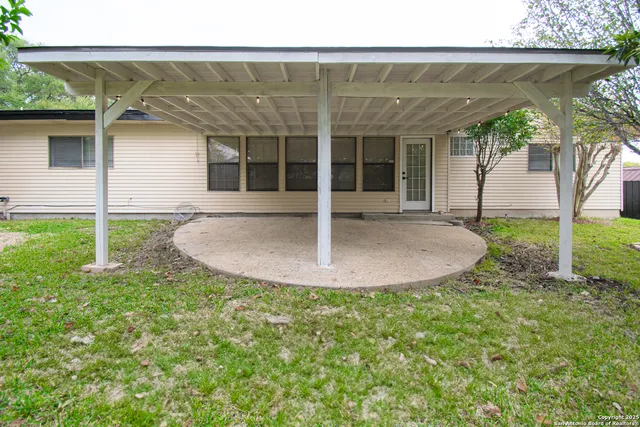 a view of a house with backyard and sitting area
