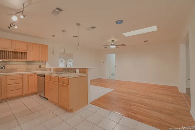 a kitchen with a sink cabinets and wooden floor