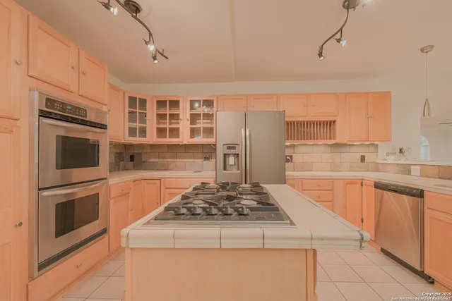 a kitchen with stainless steel appliances granite countertop a stove sink and cabinets