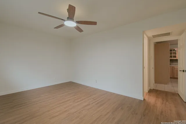 a view of empty room with wooden floor and window