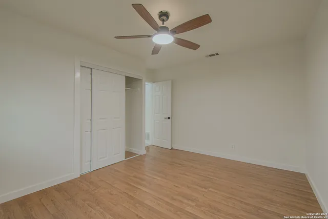an empty room with a window and a fan