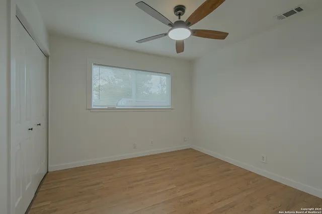 a view of empty room with ceiling fan