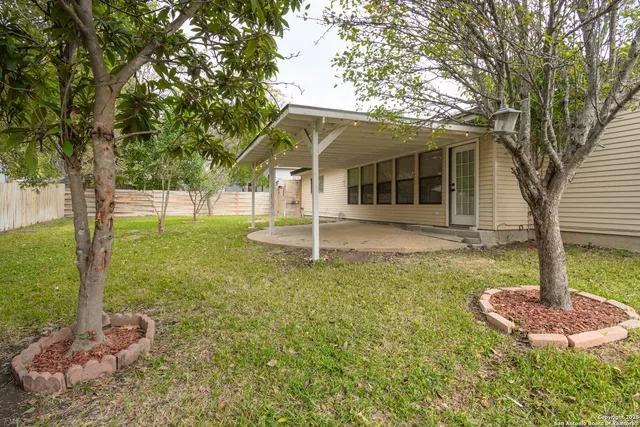 a backyard of a house with table and chairs