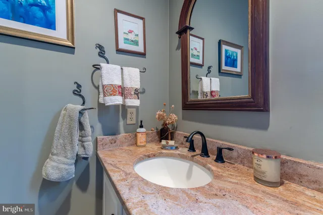 a bathroom with a granite countertop sink and a mirror
