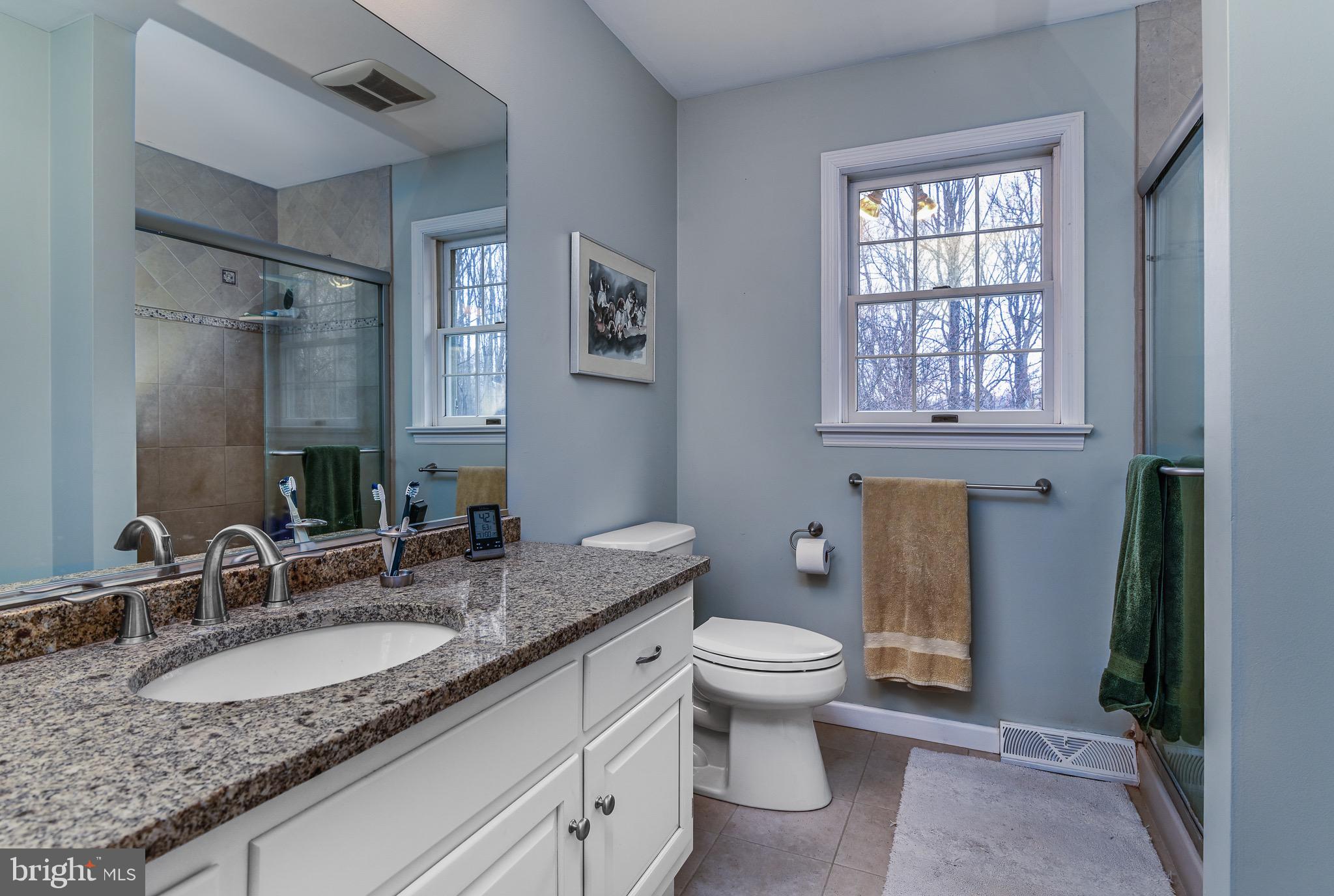 12 Phillips Lane Chester Springs, PA 19425 - Photo 33 of 54 a bathroom with a granite countertop sink a toilet a mirror and window