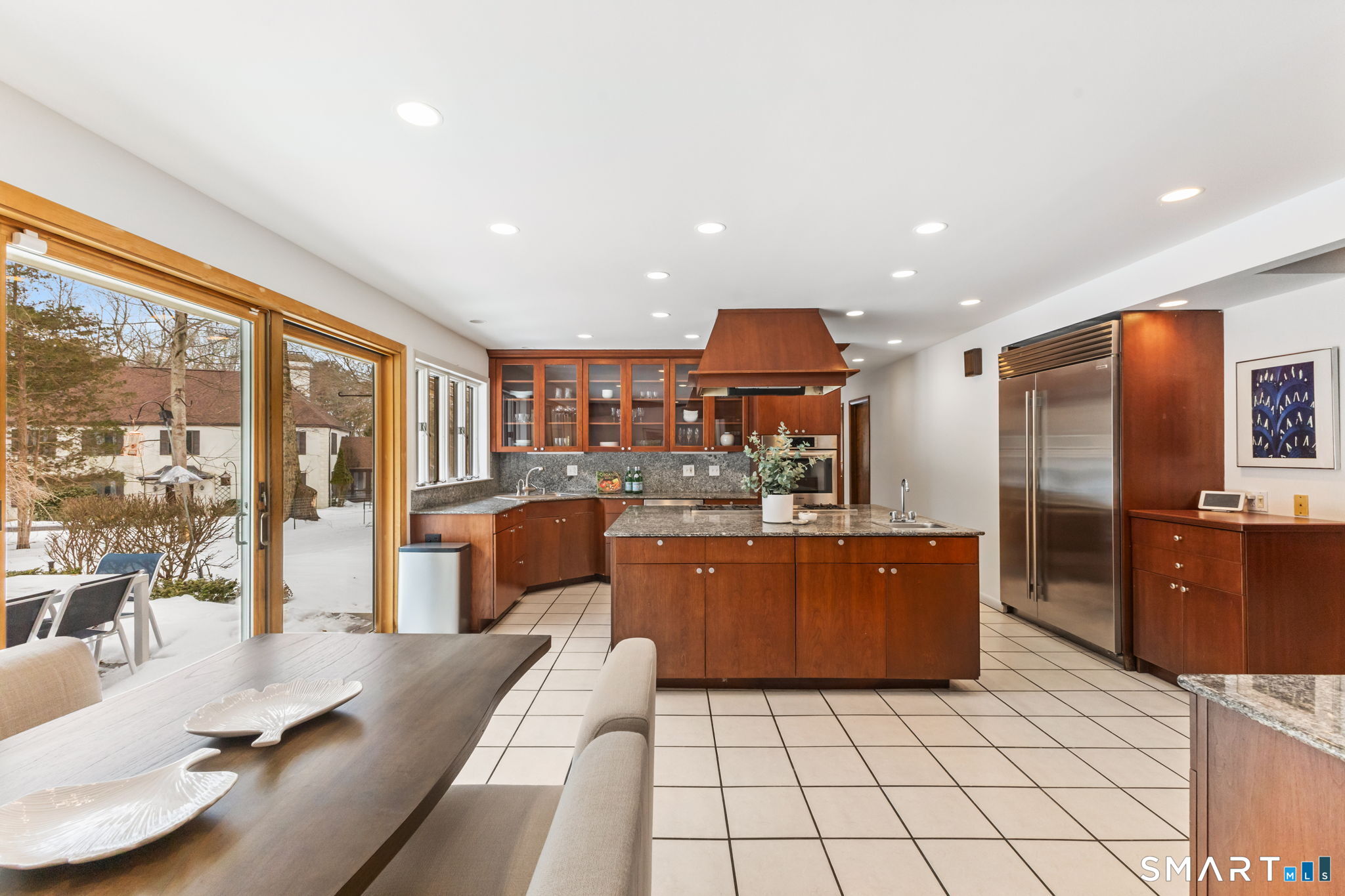 37 Quarry Road Stamford, CT 06903 - Photo 9 of 41 a large kitchen with stainless steel appliances kitchen island granite countertop a refrigerator a stove a sink a dining table and chairs with wooden floor