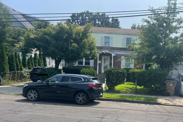 a car parked in front of a white house