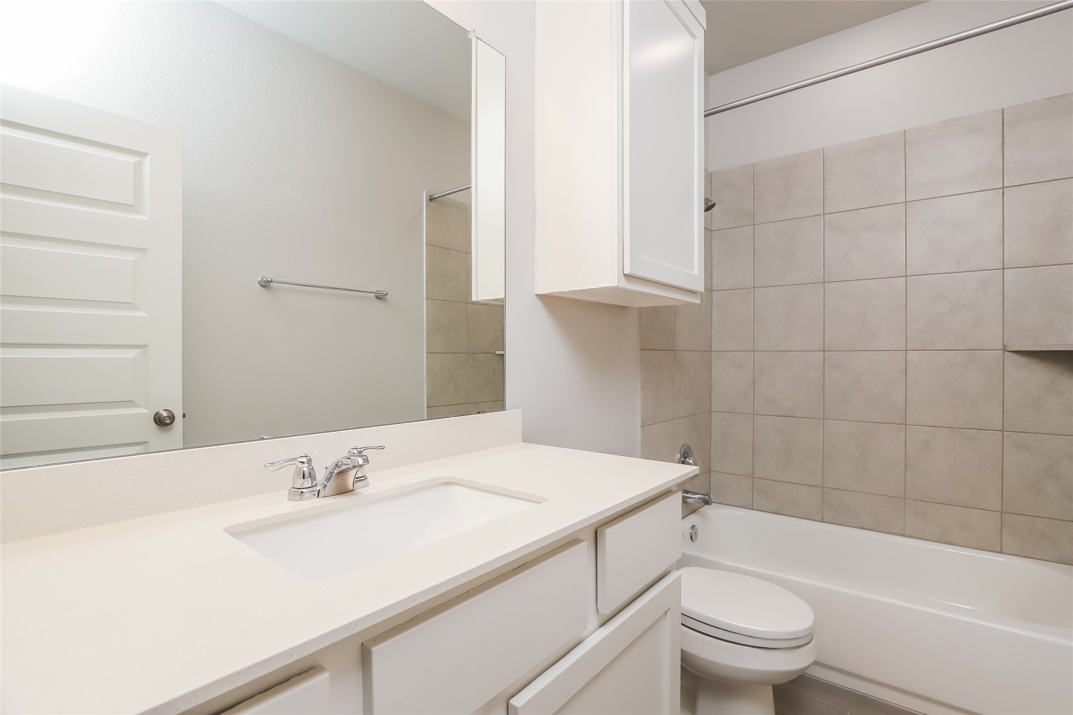 2724 Juniper Woods Road Leander, TX 78641 - Photo 16 of 21 A well-appointed bathroom features a single vanity, ample mirror, and tiled shower surround.
