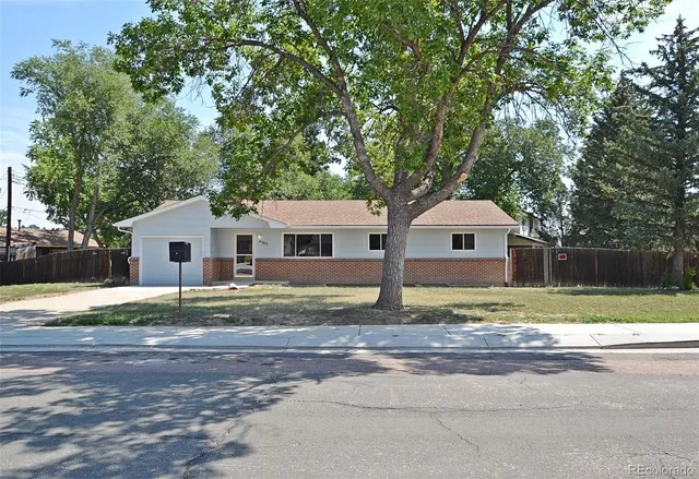 a white house that has a tree in front of it