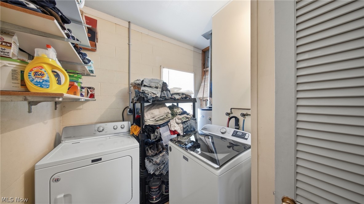 89 Dagg Road Parkersburg, WV 26101 - Photo 35 of 45 Dedicated utility area featuring a washer and dryer, wall-mounted shelving for storage, and a louvered door