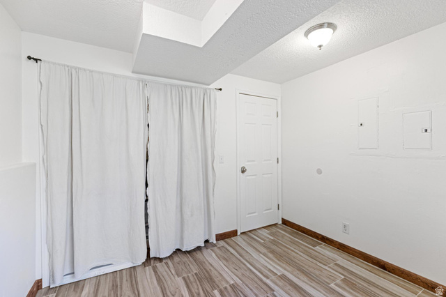 814 Mountain Road Logan, UT 84321 - Photo 30 of 42 Recessed ceiling with wood-finish flooring, featuring white paneled walls and a white six-panel door
