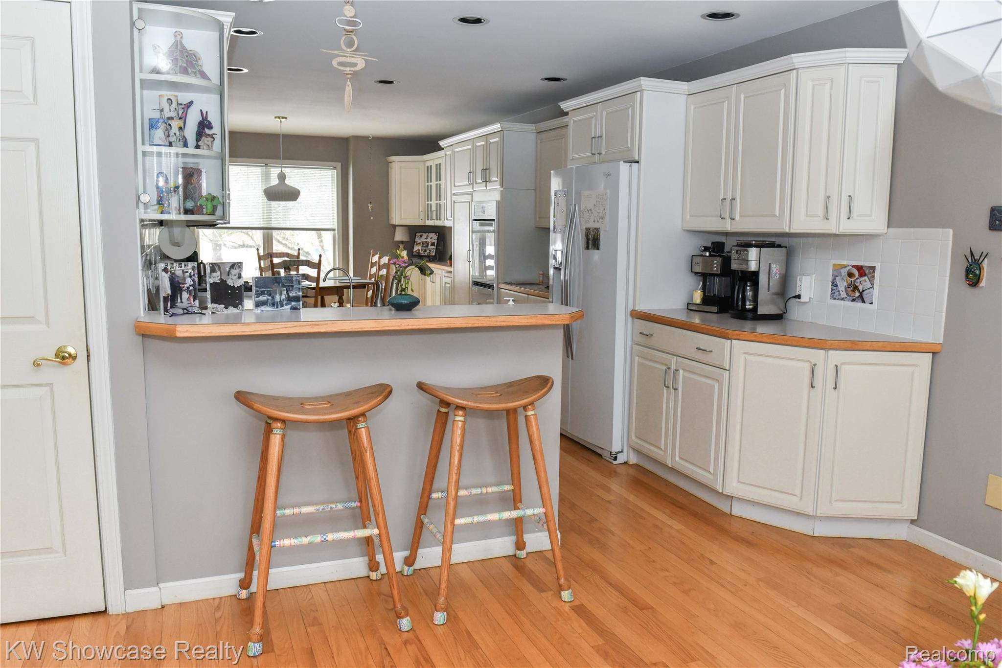3559 Timber Ridge Drive Metamora, MI 48455 - Photo 10 of 35 Kitchen featuring a kitchen breakfast bar, pendant lighting, white appliances, white cabinetry, and a peninsula