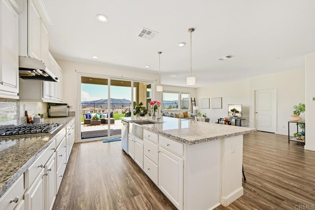 4634 Silent Knoll Drive Fallbrook, CA 92028 - Photo 9 of 26 a large kitchen with stainless steel appliances granite countertop a lot of counter space and wooden floors