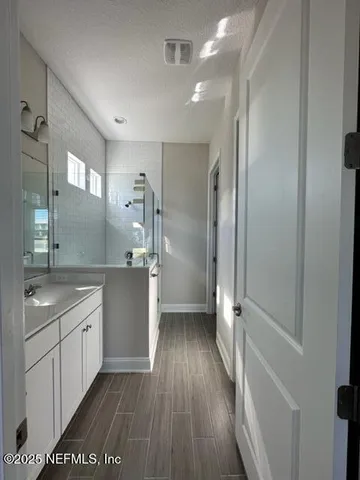 a bathroom with a sink a toilet a mirror and shower