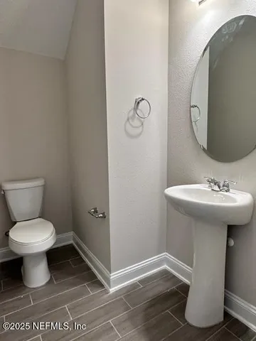 a bathroom with a toilet sink and a mirror