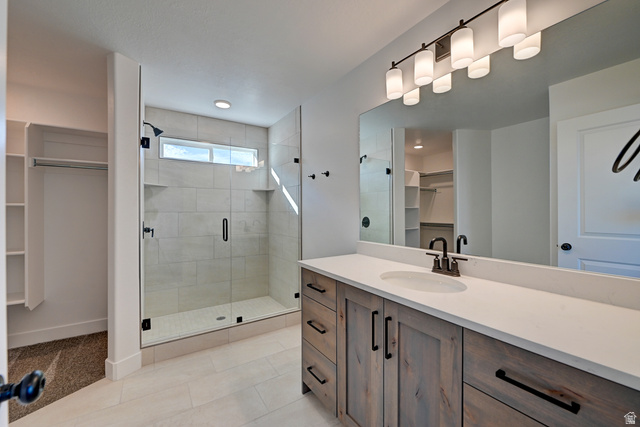 1848 Mantle Way, Unit 417 Tooele, UT 84074 - Photo 6 of 6 Contemporary bathroom featuring a spacious walk-in shower with clear glass enclosure and tiled walls