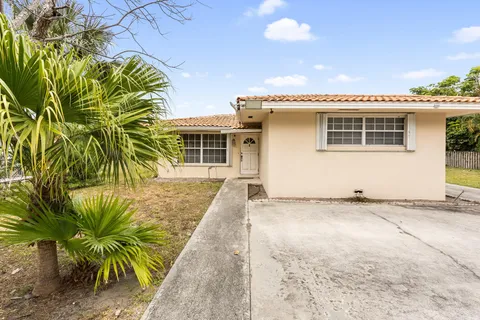 a view of a patio with table and chairs under an umbrella