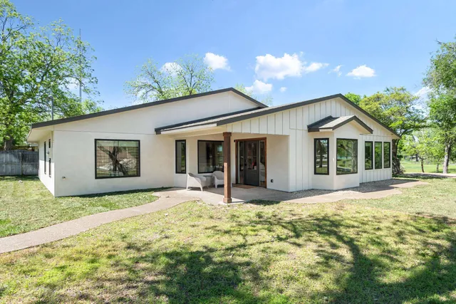 a living room with furniture a flat screen tv and a large window